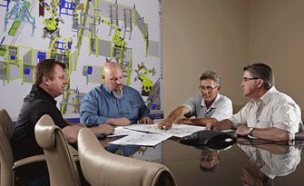 Four EnG engineers reviewing drawings at the conference table